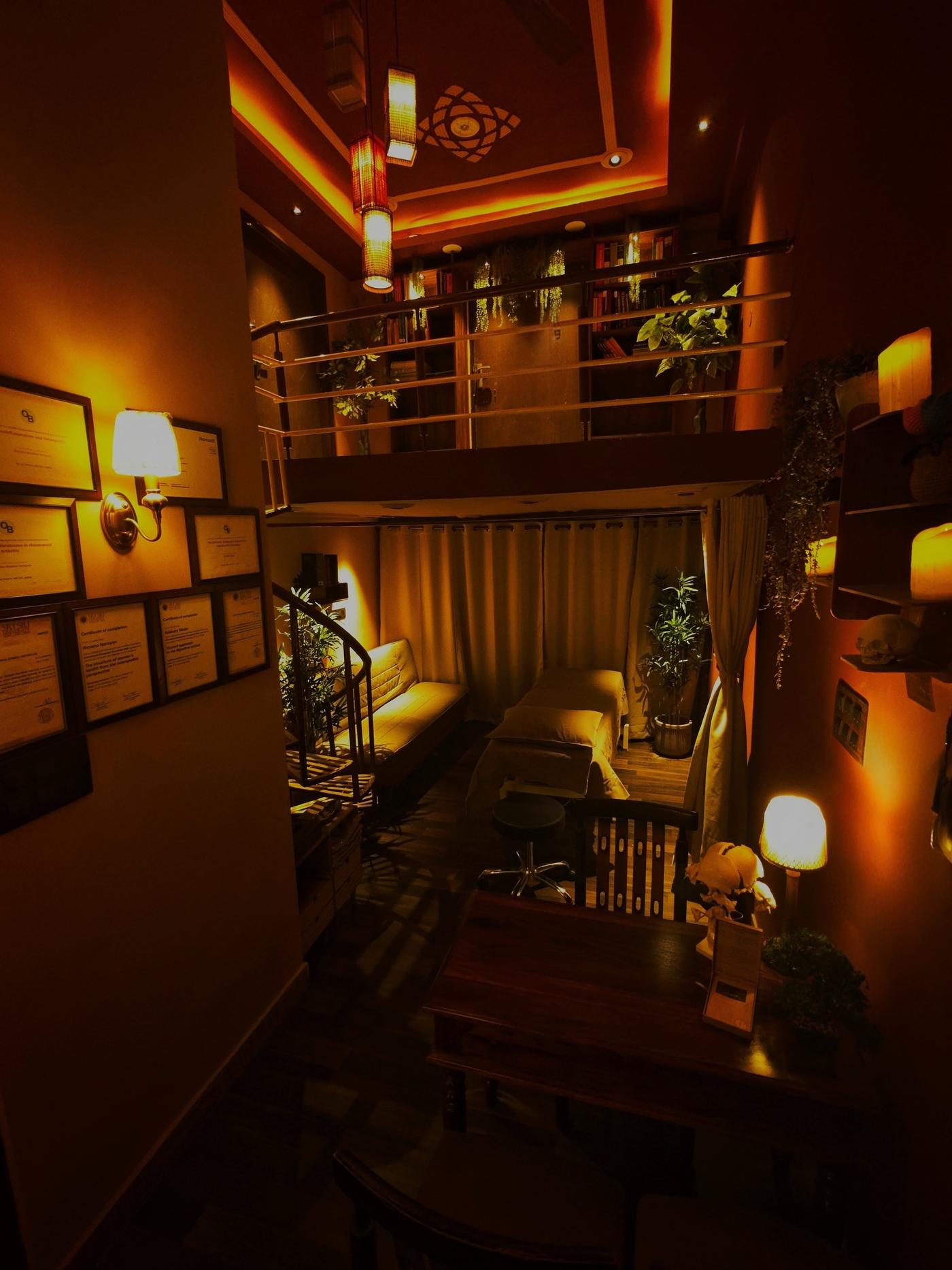 Sereñyā clinic overview — double-height treatment space with ambient lighting